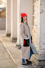 Beautiful girl in a red cap walks through the city