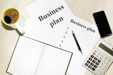 An inscription of the business plan, execution points, there is a notebook and a calculator next to...