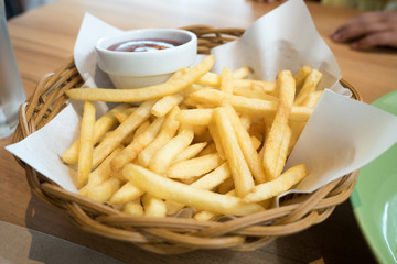 Tasty french fries with dipping in  basket on wooden table background