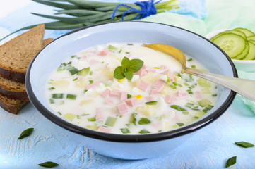 Light diet soup with fresh cucumbers, seasoned with yogurt in bowls on light background. Traditional Russian dish - 