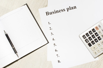 An inscription of the business plan, execution points, there is a notebook and a calculator next to it