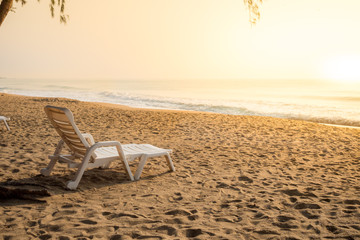 Fototapeta na wymiar white chair on sand beach in morning light