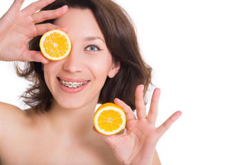 Young woman with multi-colored braces posing with lemons in hands. Isolated on white