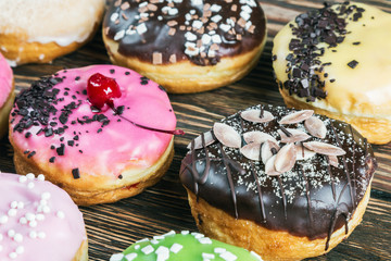 Glazed donuts with different fillings on a wooden table