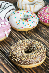 Donuts in a glaze assorted on a wooden table
