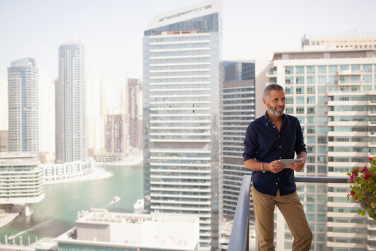Man holding digital tablet at balcony.