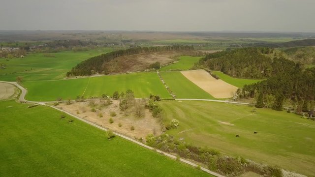 Aerial: flying over the agrarian hilly fields in La Roche Area, Belgian Ardennes