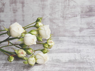 Little white roses on a bleached board. Floral background.
