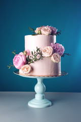 Pink cream wedding cake decorated with fresh roses