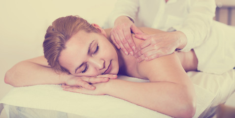 Woman taking massage in salon
