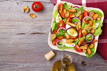 Delicious salad with chicken, nuts, egg and vegetables.