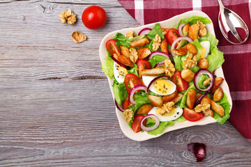 Delicious salad with chicken, nuts, egg and vegetables.