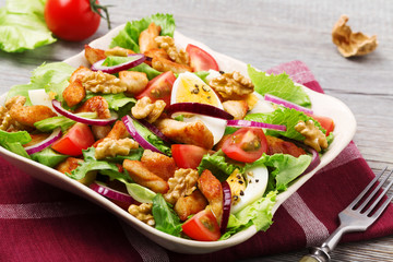 Delicious salad with chicken, nuts, egg and vegetables.