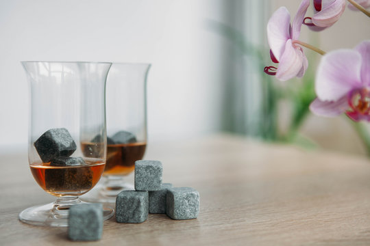 Stones for cooling whiskey and glases tulup on light wooden background