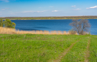 Early spring landscape with an earth road leading to Dniepr river in central Ukraine