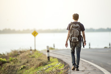 Rear View Of traveler On Vacation Hitchhiking Along Road