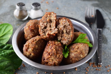 Meatballs with buckwheat in a metal bowl on a grey abstract background.Healthy food.Healthy eating concept