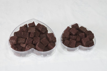 Cookies, brownies, heart-shaped box on a white background.