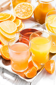 fresh citrus juices on white table, vertical top view