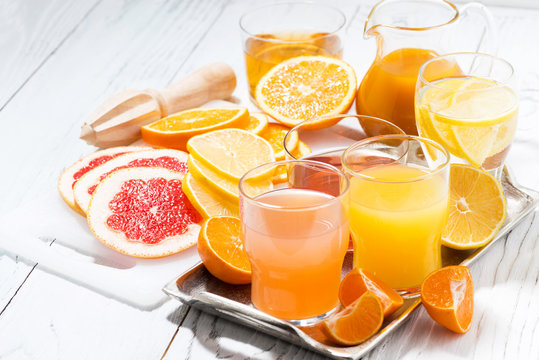 fresh citrus juices on white table