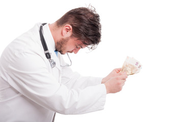 Side view of male doctor giving money