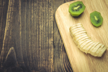 concept of healthy food with banana and kiwi/banana and kiwi on a wooden surface. Top view