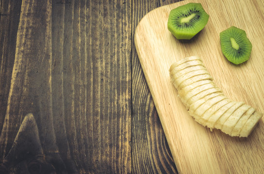 concept of healthy food with banana and kiwi/banana and kiwi on a wooden surface. Top view