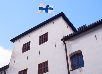 Finnish flag on the roof of the Turku castle in Finland in bright sunshine