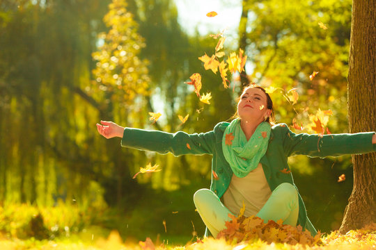 Happy Woman Throwing Autumn Leaves In Park