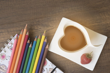 Blank notepad and pen with latte art coffee on office table