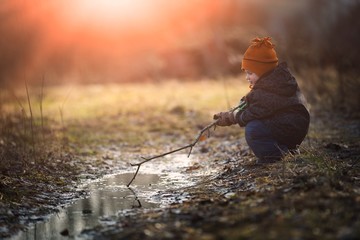 Little boy playing in puddle at springtime - 143885362