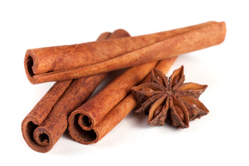three cinnamon sticks with star anise isolated on white background