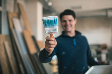 A young man at work. Painter with a brush. Concept of repair