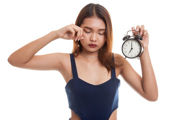 Sleepy young Asian woman with a clock in the morning.