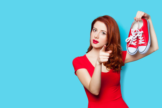 photo of beautiful young woman with red gumshoes on the wonderful blue background