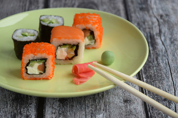 Set of rolls on the plate with ginger, wasabi and chopsticks