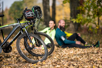 Fototapeta na wymiar Bikes and couple of cyclists in park