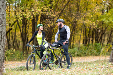 Naklejka premium Cyclists with bikes in autumn park