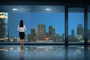 Back view of asian business woman standing looking at the city