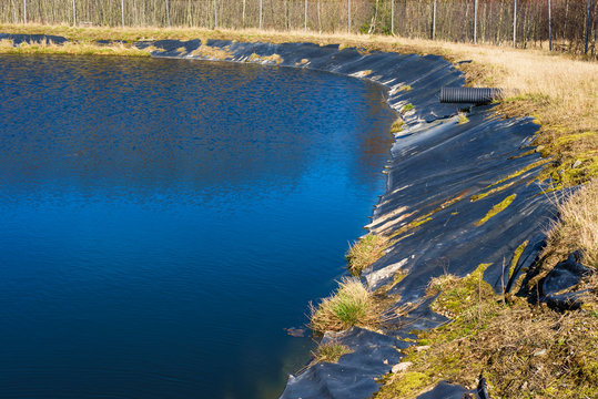 Leachate pond with synthetic lining and surrounding fence. Location Ronneby, Sweden.