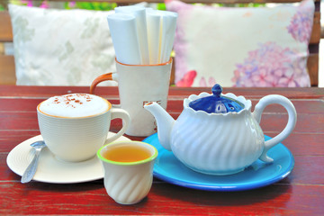 Cup of cappuccino, cup of coffee on brown wooden table.