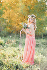 Bridesmaid in pink dress with bouquet.