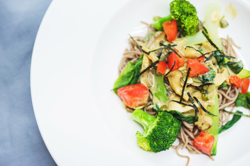 Broccoli, tomatoes and noodles with mushrooms. Tasty and healthy food. Soft focus. Top view.