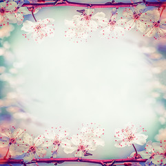 Springtime floral frame with pretty cherry or sakura blossom, at bokeh background