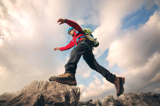 Mountaineer jumps over rocks in mountin