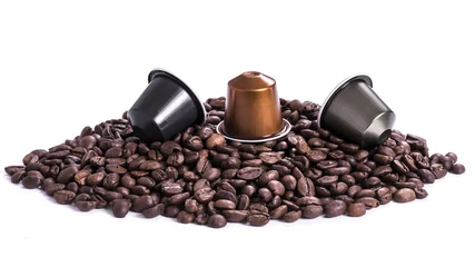 Rolgordijnen koffiebonen en capsules op witte achtergrond © Maurice Metzger