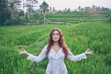 Yoga with view of green fields. Young woman with opened hands. Concept of calm and meditation.