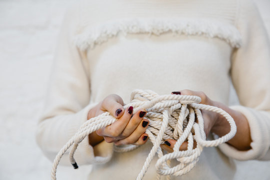 Hands holding white yarns