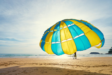 Silhouette of man is preparing para sailing on beach in Thailand