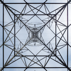 Electricity pylon abstract. Abstract view looking up at the construction of a UK electricity pylon with clear sky background.